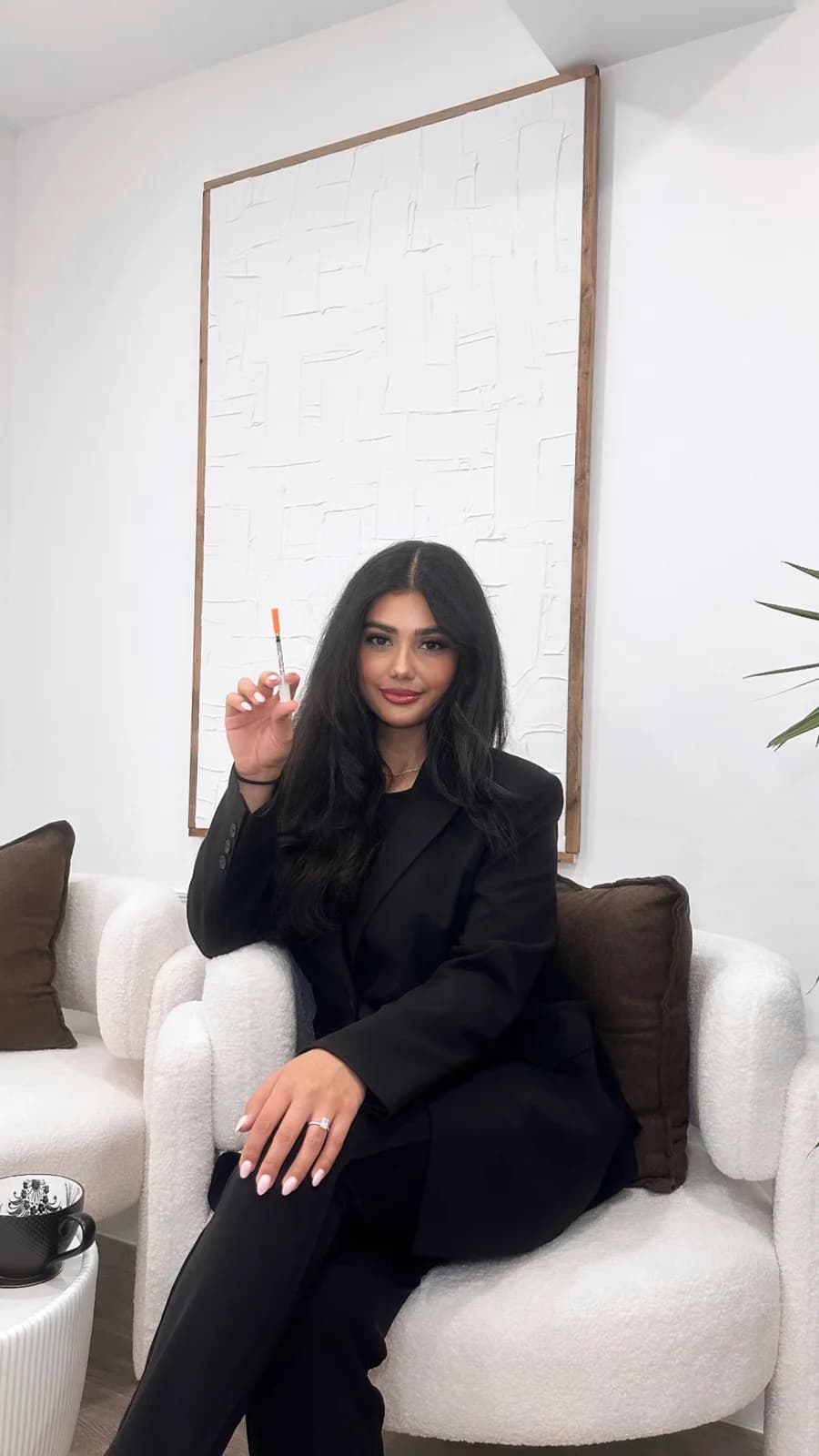 Nurse Tamana seated in the clinic holding a syringe for injectable treatment planning