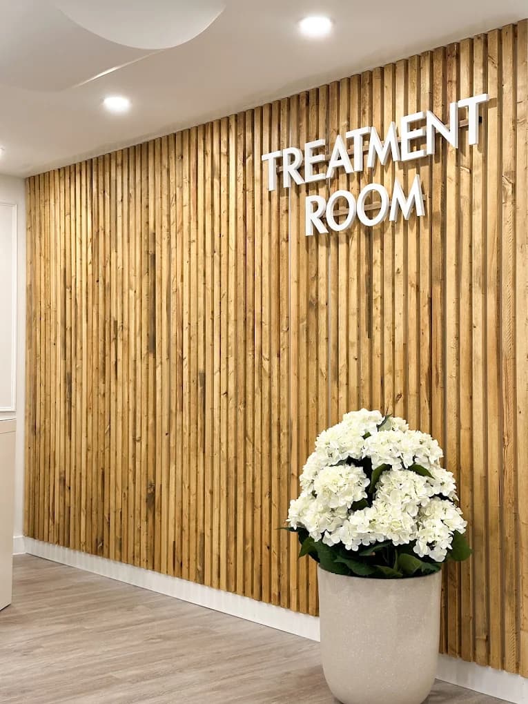 Treatment room wood-slat feature wall with fresh floral accent